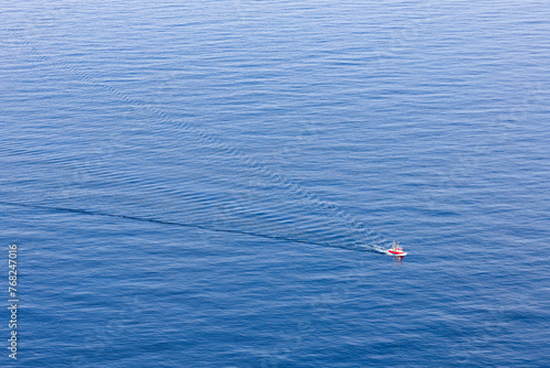 Fisherboat on the blue wide ocean with calm sea