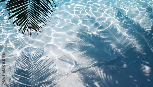Blue water surface with shadows of palm leaves. Summer time and swimming pool vibes.