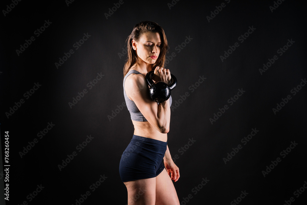 Young female doing swing exercise with a kettle bell. Fitness woman