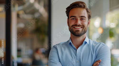 Portrait of a handsome young businessman smiling at the camera while standing in a cafe photo