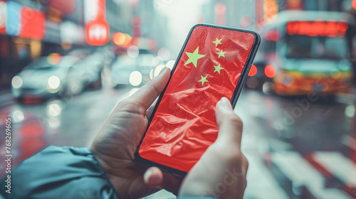 Hands with mobile phone with Chinese flag on the background on the street