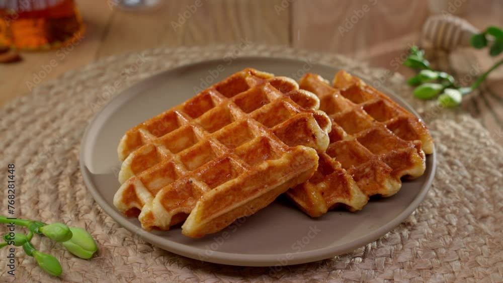 Belgian Waffle Dusted with Powdered Sugar. Perfectly cooked Belgian waffle topped with dusting of powdered sugar on ceramic plate. Belgian Waffle Dusted with Powdered Sugar. Perfectly cooked Belgian waffle topped with dusting of powdered sugar on ceramic plate.