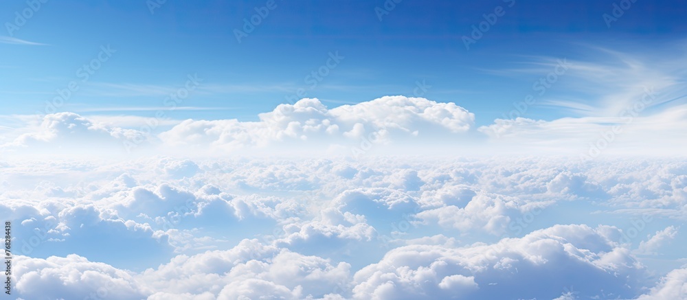 A picturesque natural landscape with a fluid blue sky adorned with fluffy white cumulus clouds, creating a serene horizon filled with meteorological phenomena A picturesque natural landscape with a fluid blue sky adorned with fluffy white cumulus clouds, creating a serene horizon filled with meteorological phenomena