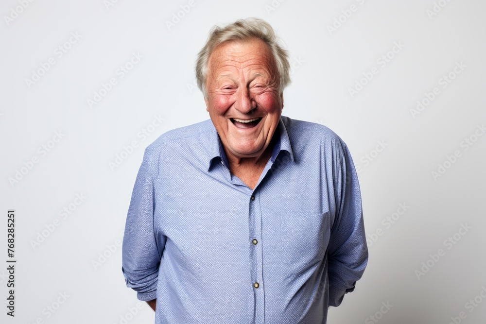Portrait of a happy senior man laughing over grey background. Studio shot. Portrait of a happy senior man laughing over grey background. Studio shot.