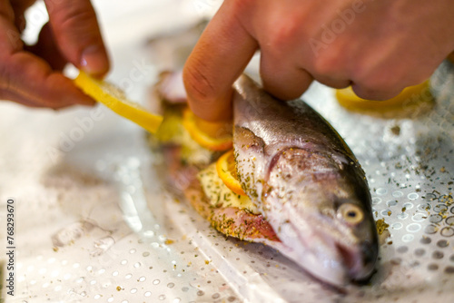 Preparing trouts with lemons butter and green dill. 