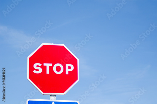 isolated stop sign with blue sky background, road safety concept