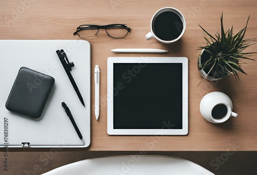 Top view of a minimalist desk with a tablet and pens on it
