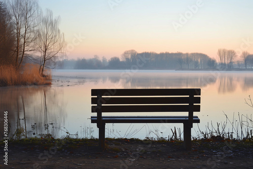 A park chair next to a lake, loneliness concept