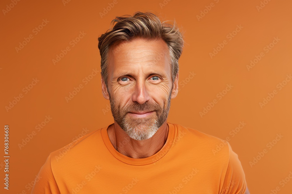 Handsome middle-aged man in orange t-shirt on orange background Handsome middle-aged man in orange t-shirt on orange background