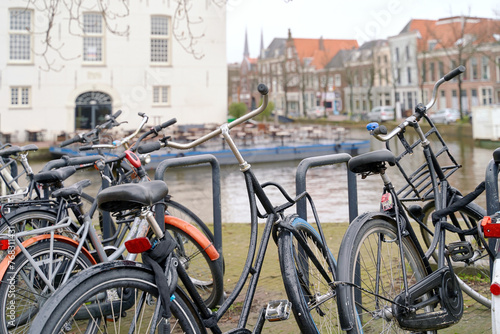 Delft, Netherlands. Bicycles parked alongside a channel on beautiful old buildings background.