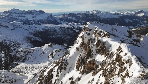 Drone ascending over a mountain ridge covered with snow. Dolomites, Italy