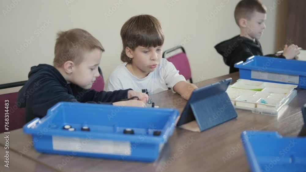 Children engage in STEM learning activities, assembling robotics kits ...
