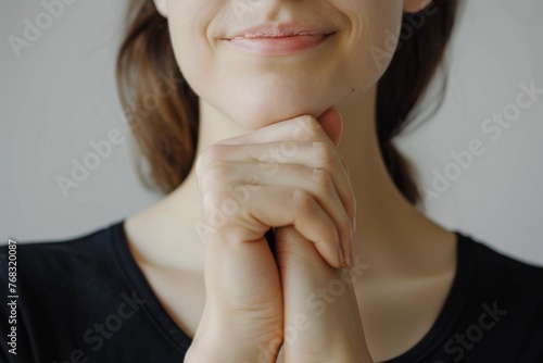 A close-up image showing a woman's smile with a focus on lips and hand, conveying joy or satisfaction