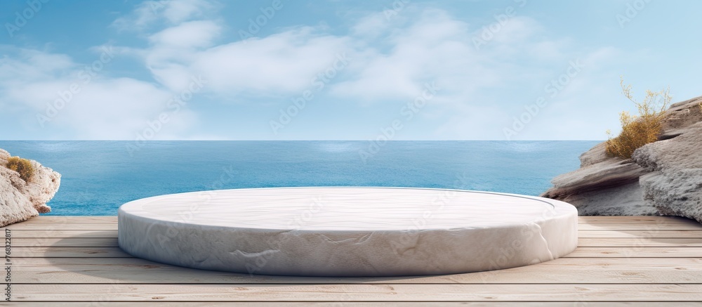 A white marble podium sits on a wooden dock by the azure ocean, beneath a cloudfilled sky. The landscape features a horizon where water meets the sky