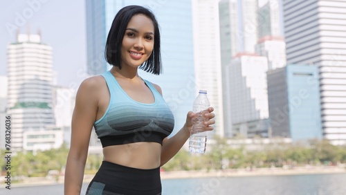 Free Download Active Woman Holding Water Bottle in Urban Park - GFXLoad
