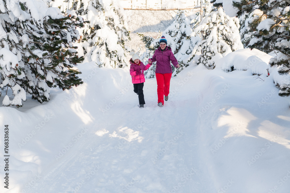 A Mother and Daughter's Blissful Run Along a Snowy Winter Path