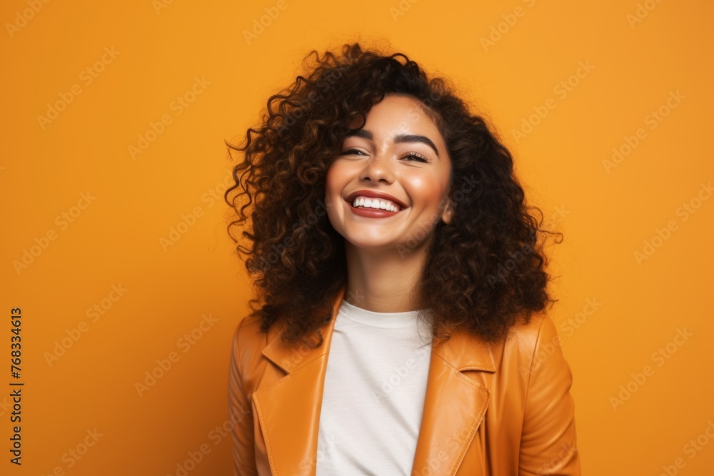 Cheerful african american woman in leather jacket on orange background Cheerful african american woman in leather jacket on orange background