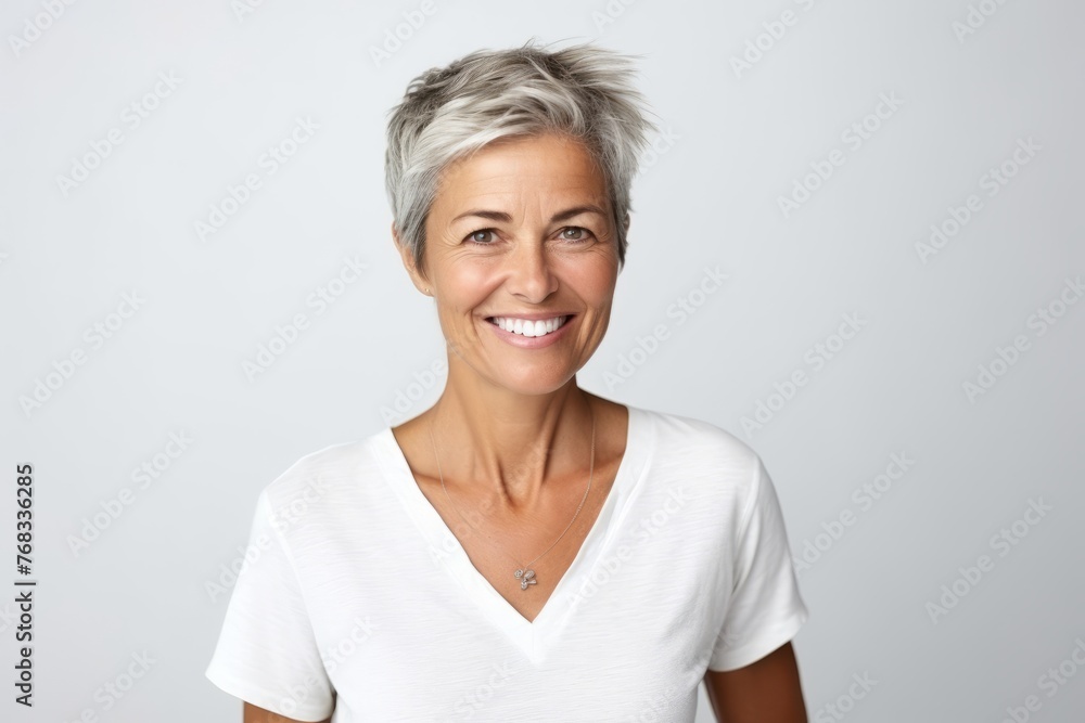 Portrait of smiling senior woman with short grey hair against white background Portrait of smiling senior woman with short grey hair against white background