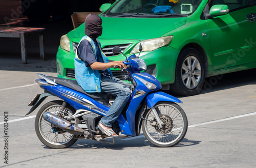 Canvas Print The mototaxi driver in a blue vest ride on the street, Thailand