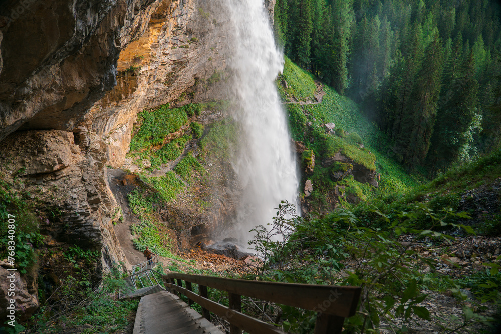 Waterfall and stairs to the waterfall. Rushing water falls on large ...