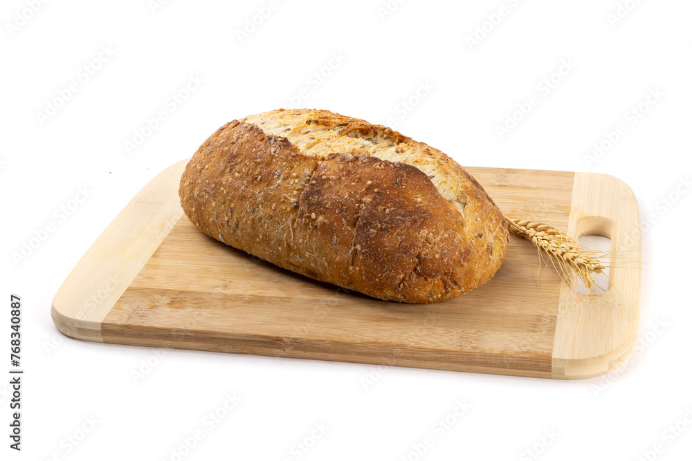 A whole loaf of artisanal crusty bread on a wooden cutting board isolated on white A whole loaf of artisanal crusty bread on a wooden cutting board isolated on white