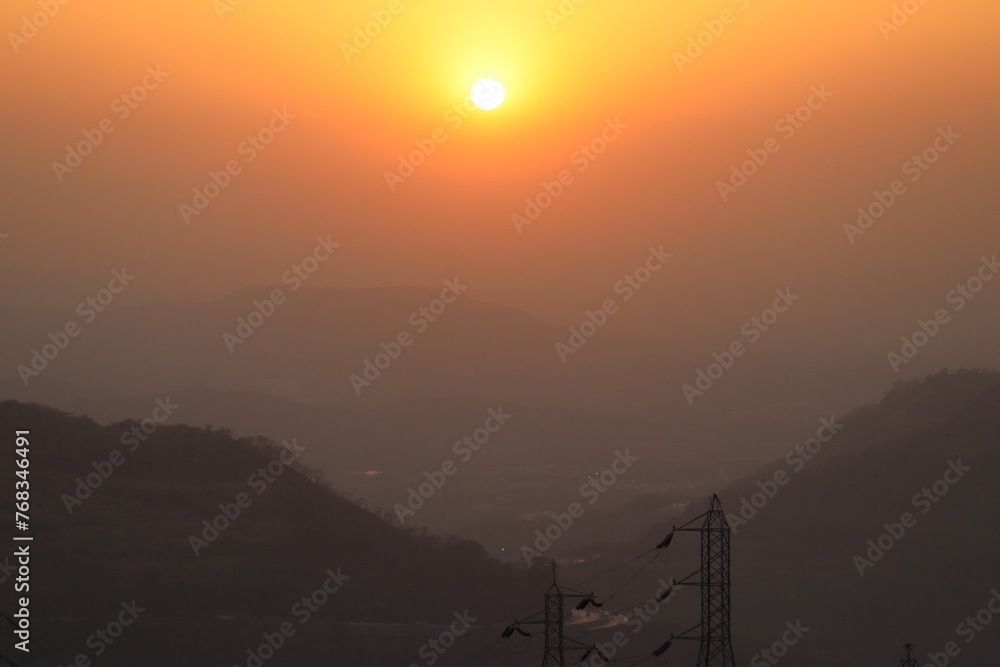 Obraz premium The sun is setting between the mountains