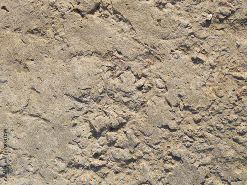 The texture of old concrete with stones frozen in it. Closeup