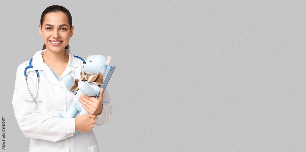 Portrait of female pediatrician on grey background with space for text Portrait of female pediatrician on grey background with space for text