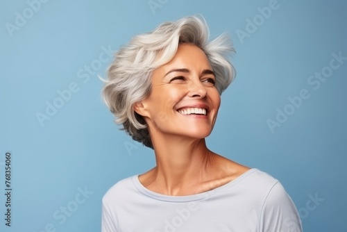 happy senior woman with grey hair and closed eyes over blue studio background