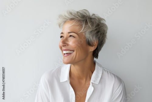 Portrait of happy senior woman with short grey hair smiling at camera