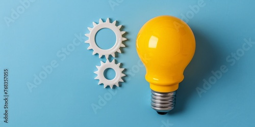 Yellow light bulb and gears on blue background, concept of ideas and creativity