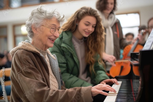 A joyful elder piano instructor plays and teaches with smiling teens surrounding her