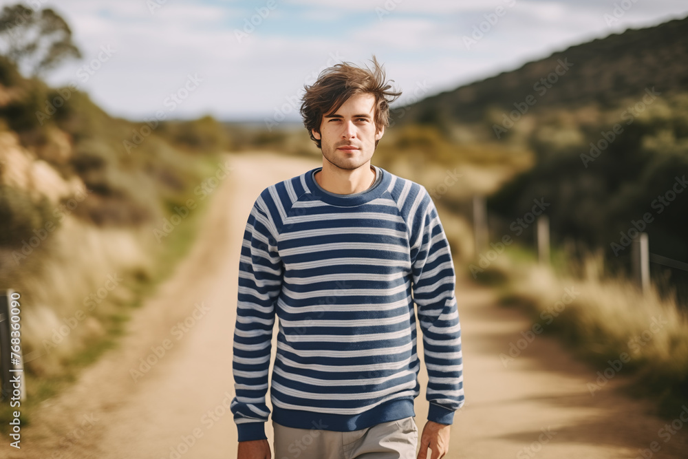 Casual young man in striped sweater on rural road, carefree lifestyle, freedom and nature concept. Casual young man in striped sweater on rural road, carefree lifestyle, freedom and nature concept.