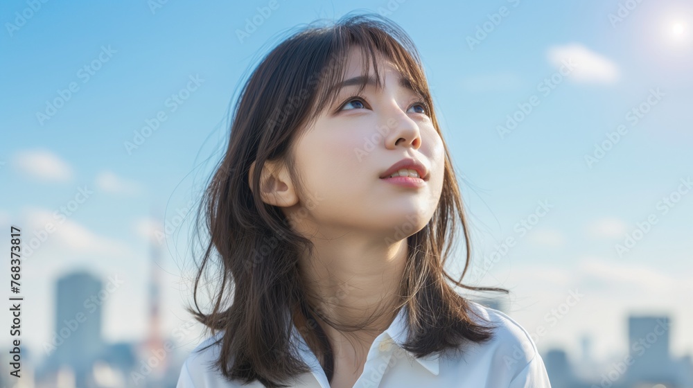 Japanese woman wearing a white shirt and looking up at the sky. Japanese woman wearing a white shirt and looking up at the sky.