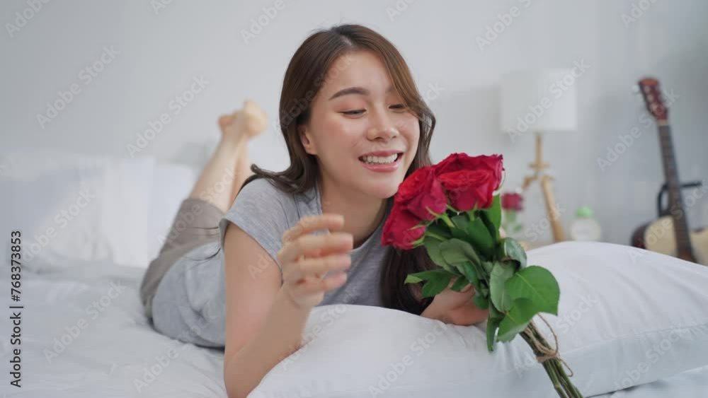 Asian young beautiful woman looking at rose flower in bedroom at home. Asian young beautiful woman looking at rose flower in bedroom at home.