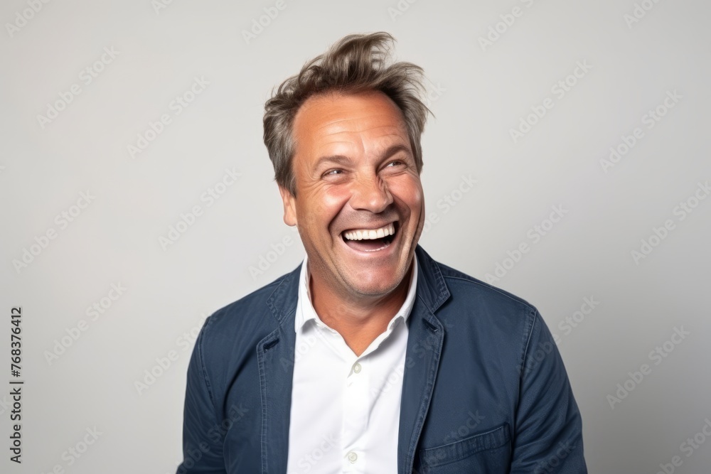 Portrait of a happy senior man laughing against a grey background. Portrait of a happy senior man laughing against a grey background.