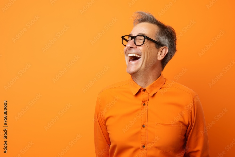 Portrait of a happy senior man in orange shirt and glasses over orange background. Portrait of a happy senior man in orange shirt and glasses over orange background.