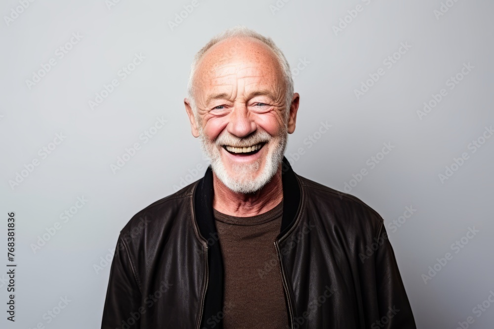 Portrait of a happy senior man laughing against a grey background. Portrait of a happy senior man laughing against a grey background.