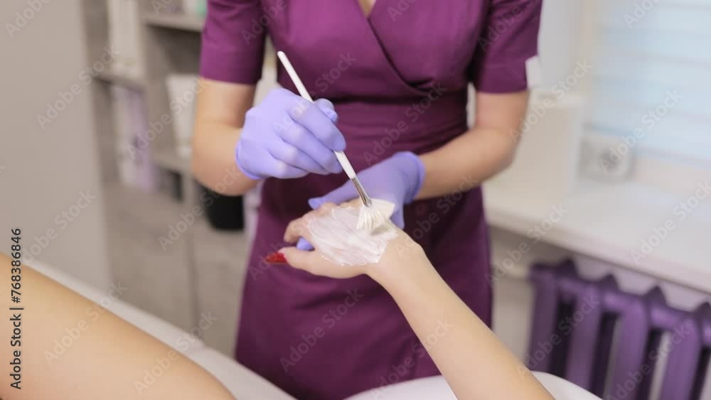 A woman is bandaging the patients wrist with care and precision A woman is bandaging the patients wrist with care and precision