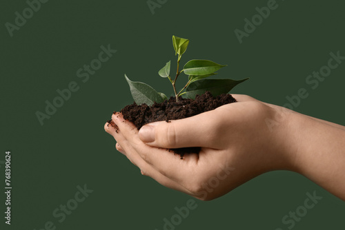 Woman holding young plant a...