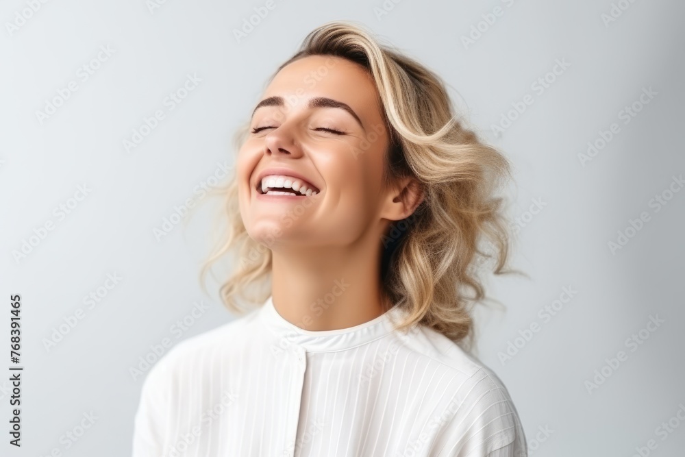 Portrait of happy smiling young beautiful blonde woman, over grey background Portrait of happy smiling young beautiful blonde woman, over grey background