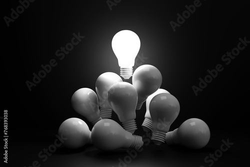 Bright light bulb floats above a white light bulb in dark. concept of talented leadership and outstanding ideas, selection of good ideas, innovations, and inspiration