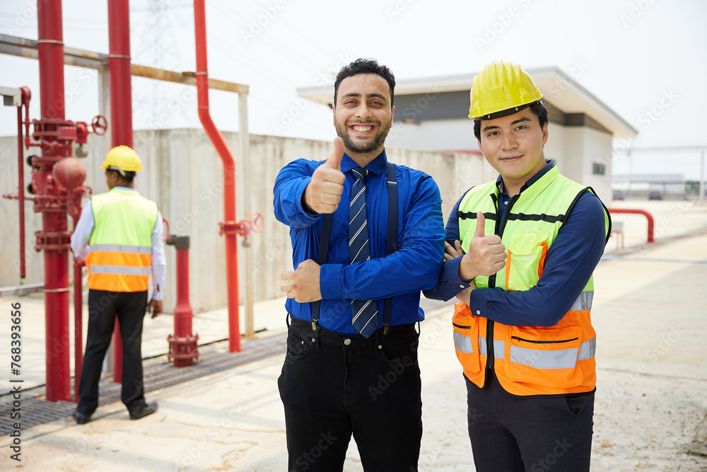worker and businessman smiling and thumbs up pose in the factory worker and businessman smiling and thumbs up pose in the factory