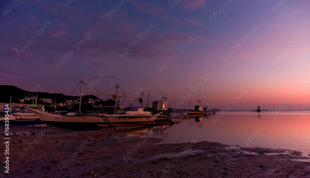Golden Sunset Reflections. Tranquil beach scene with boats silhouetted against a colorful sky during sunset