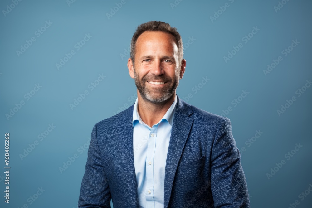 portrait of happy middle age man with beard smiling at camera over blue background portrait of happy middle age man with beard smiling at camera over blue background
