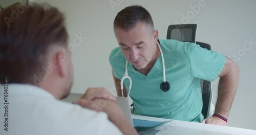 Male specialist is discussing with young, undisciplined patient who is not following the prescribed treatment. He tells him that the problem is not resolved and that he need to take it more seriously. photo