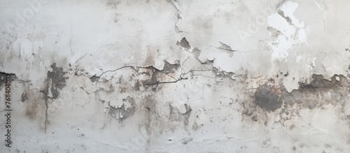 A close up of a white wall with peeling paint resembling a snowcovered landscape. The paint is cracking like freezing water in an art event
