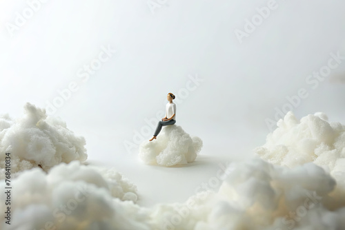 Miniature people doing yoga on tiny clouds