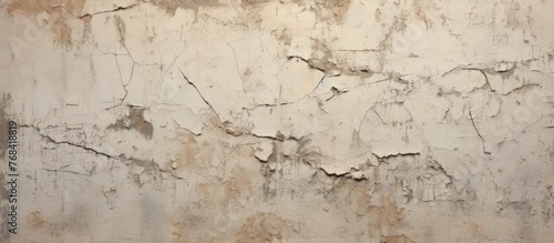 Close-up view of a wall surface where white paint is peeling off, revealing the underlying texture