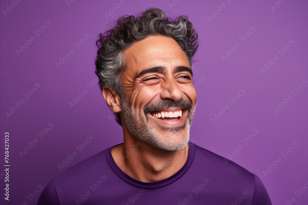 Portrait of a happy middle-aged man laughing against purple background Portrait of a happy middle-aged man laughing against purple background